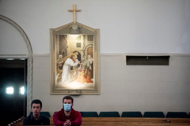 Brothers Sebastian and Michael Scriber attend Holy Week confession at St. Philip Roman Catholic Church on Wednesday, April 8, 2020 in Battle Creek, Mich. To prevent the spread of COVID-19, only 10 people are allowed inside the church at a time.