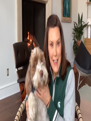 A screenshot from a Facebook post by Michigan Governor Gretchen Whitmer holding her dog, Kevin, as she reminds citizens to continue social distancing practices amid the COVID-19 pandemic on April 8, 2020. Whitmer also deemed the Easter Bunny and Tooth Fairy as essential workers so they can continue working through the pandemic.