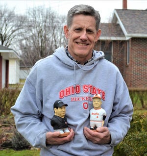 John Hoesman stands outside his Woodville home studio with two of his custom woodcarvings. Hoesman gained national attention when he was asked to create woodcarvings of the coaches during the 1996 Tostitos Fiesta Bowl.