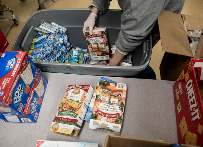 A volunteer organizes food at the Salvation Army. 