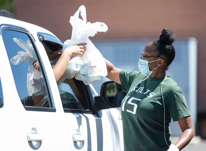 Zacona Michaux hands out lunches at Edison Elementary School on April 9, 2020. Mesa Public Schools has scaled back meal distribution and since closed the Edison site. Meals can be picked up at Kino Junior High on Mondays, Wednesdays and Fridays instead.