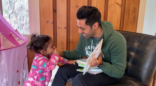 Hasan Minhaj reads to his two-year-old daughter.