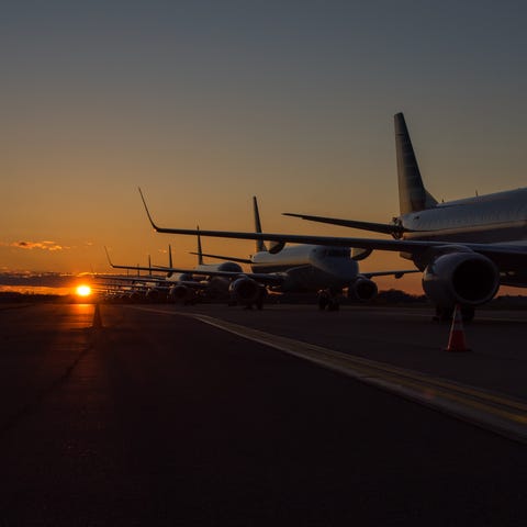 The sun sets behind a group of American Airlines j