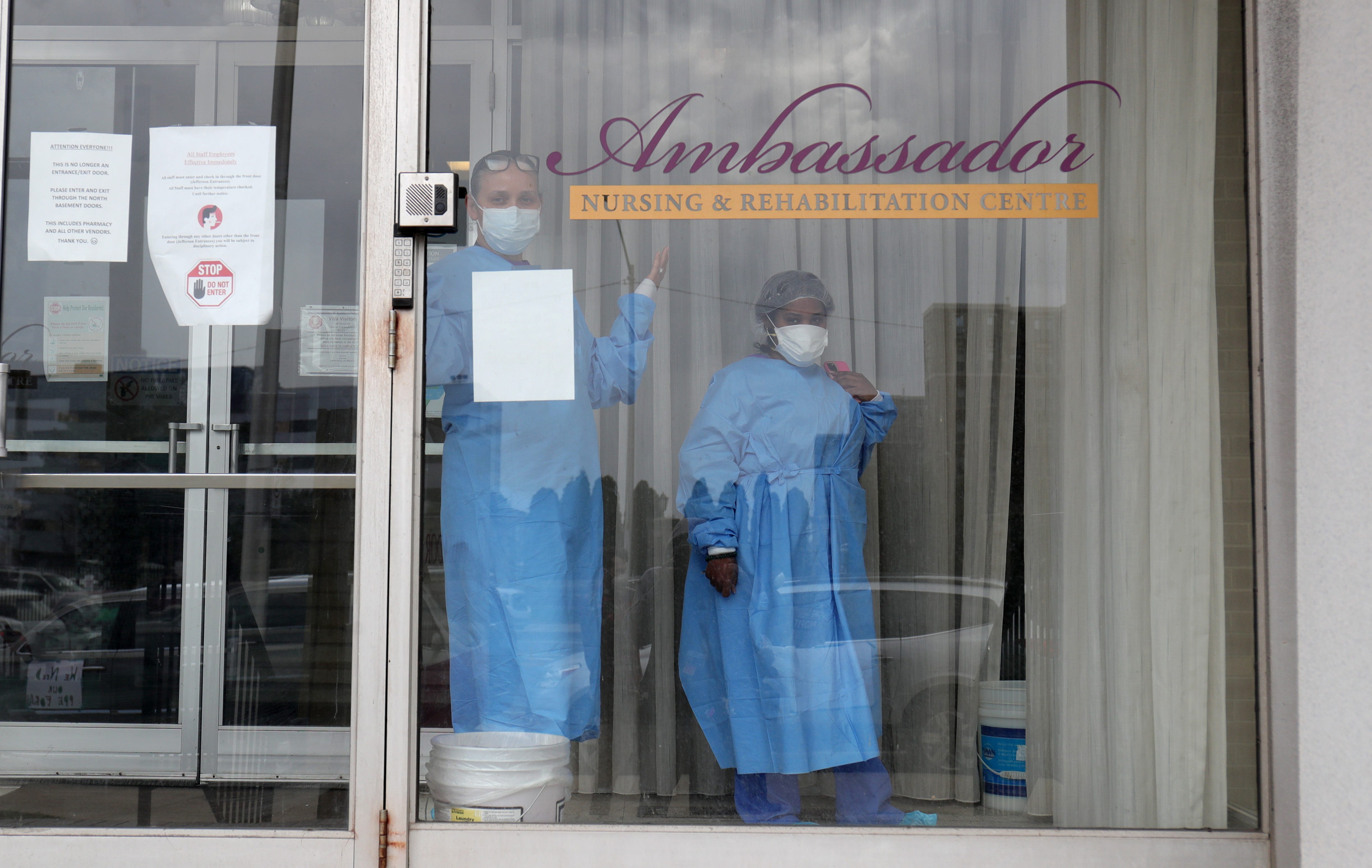 Workers watch as Rev W.J. Rideout and the SEIU Michigan Healthcare union protest working conditions at the Ambassador nursing home on April 9, 2020, in Detroit. Workers at the home were just recently given the necessary PPE needed to treat patients.