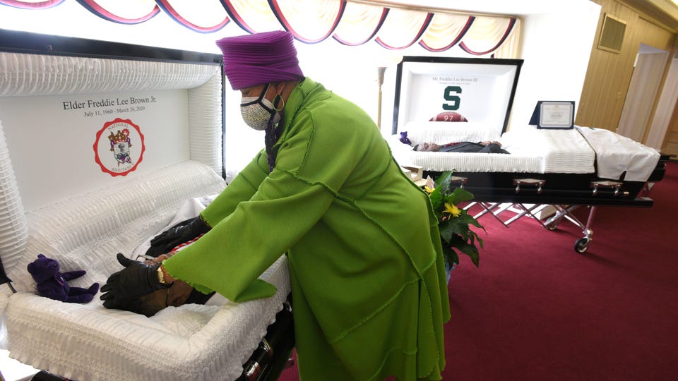 Cassandra Brown touches the forehead of her late husband, Freddie Lee Brown Jr., after she cries over her late son, Freddie Lee Brown III, right. They both recently died from COVID-19 three days apart. Cassandra Brown touches the forehead of her late husband, Freddie Lee Brown Jr., after she cries over her late son, Freddie Lee Brown III, right. They both recently died from COVID-19 three days apart.