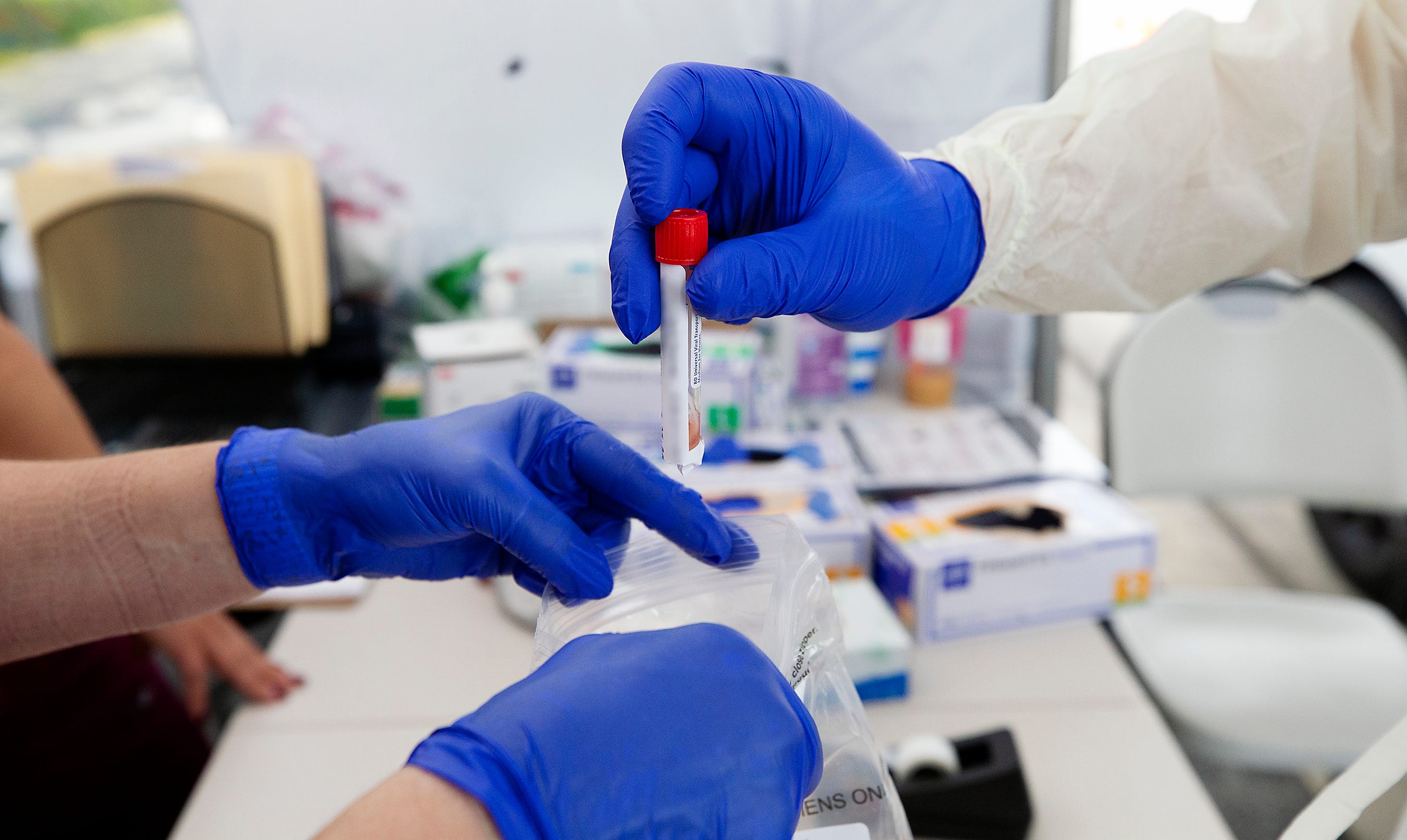 Nurses at a mobile testing site in Fort Myers, Florida, prepare a COVID-19 swab for testing.