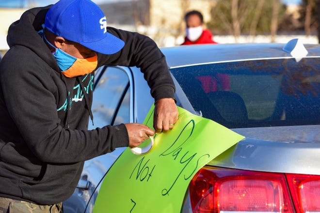Abel Argo tapes a sign to his car before participating in a protest in solidarity with Smithfield Food, Inc. employees after many workers complained of unsafe working conditions due to the COVID-19 outbreak on Thursday, April 9, in Sioux Falls. This week, over 80 Smithfield employees tested positive for the virus, and the plant is closing for just three days before expecting workers back.