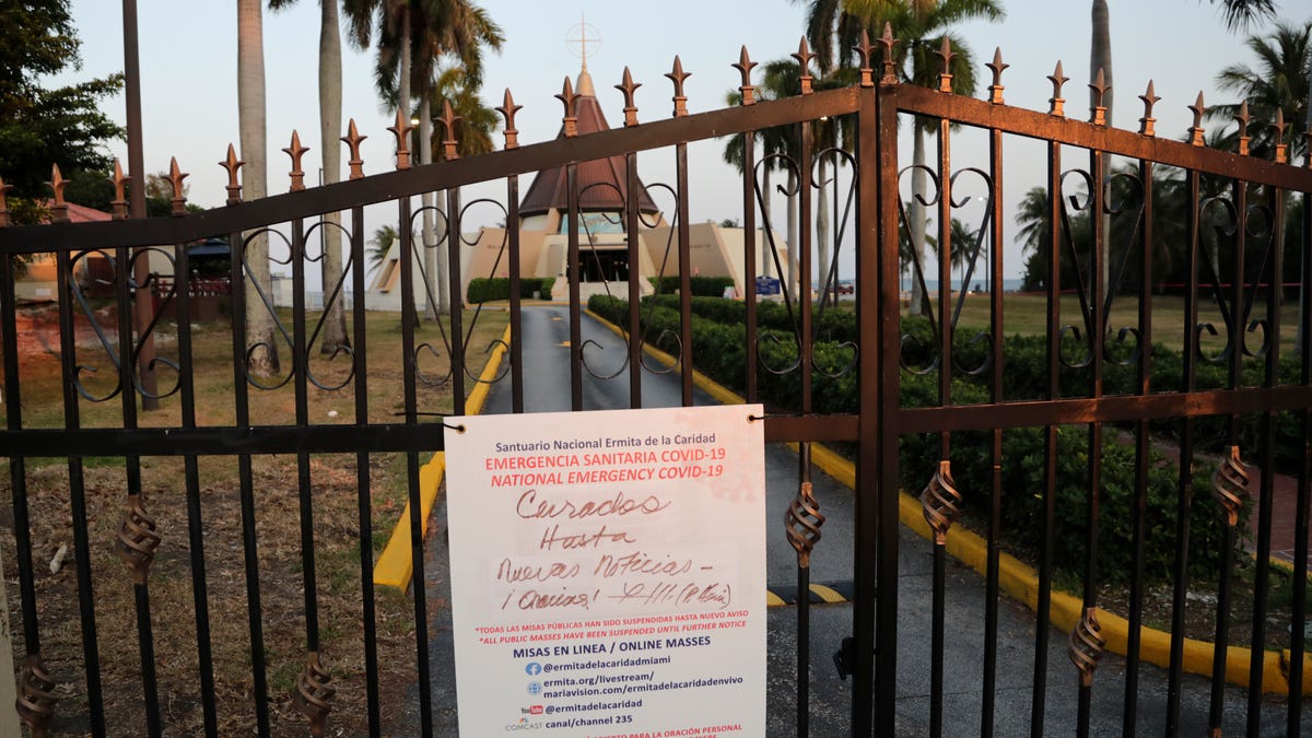 A sign hanging on a locked gate in front of the Ermita de la Caridad church in Miami indicates that the church is closed during the new coronavirus pandemic, Churches are closed in South Florida as religious leaders worldwide are urging people to celebrate Good Friday and Easter from the safety of their homes.