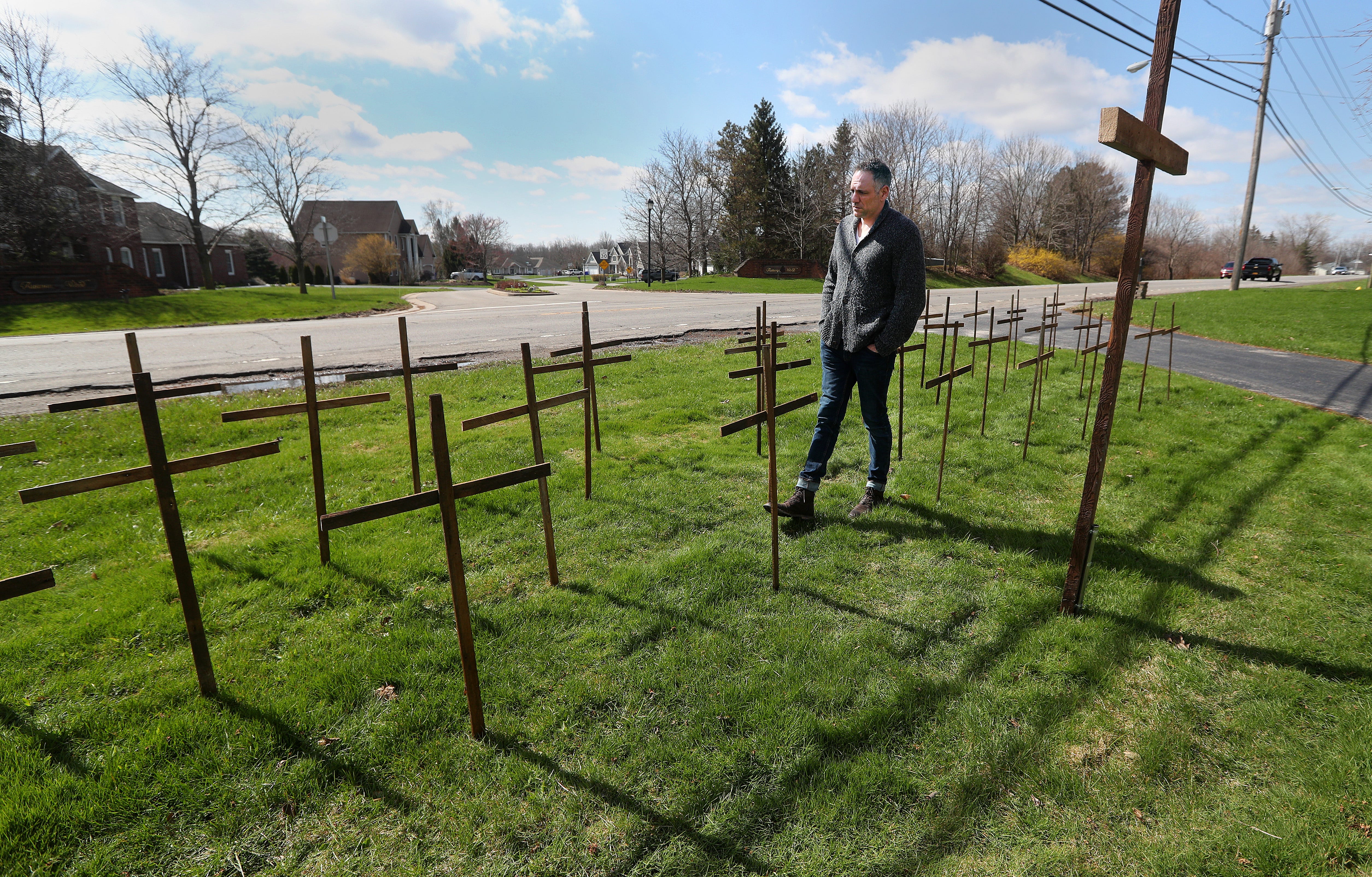 The virus continued its merciless path throughout 2020, claiming New Yorkers daily. In front of his Chili home in April, Jim Corbett walks through the rows of wooden crosses he's placed for each person in Monroe County who has died of COVID-19.