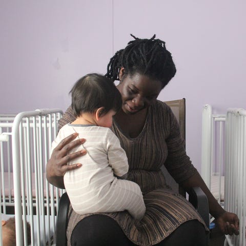 Shemonica Flemings comforts an infant at her dayca