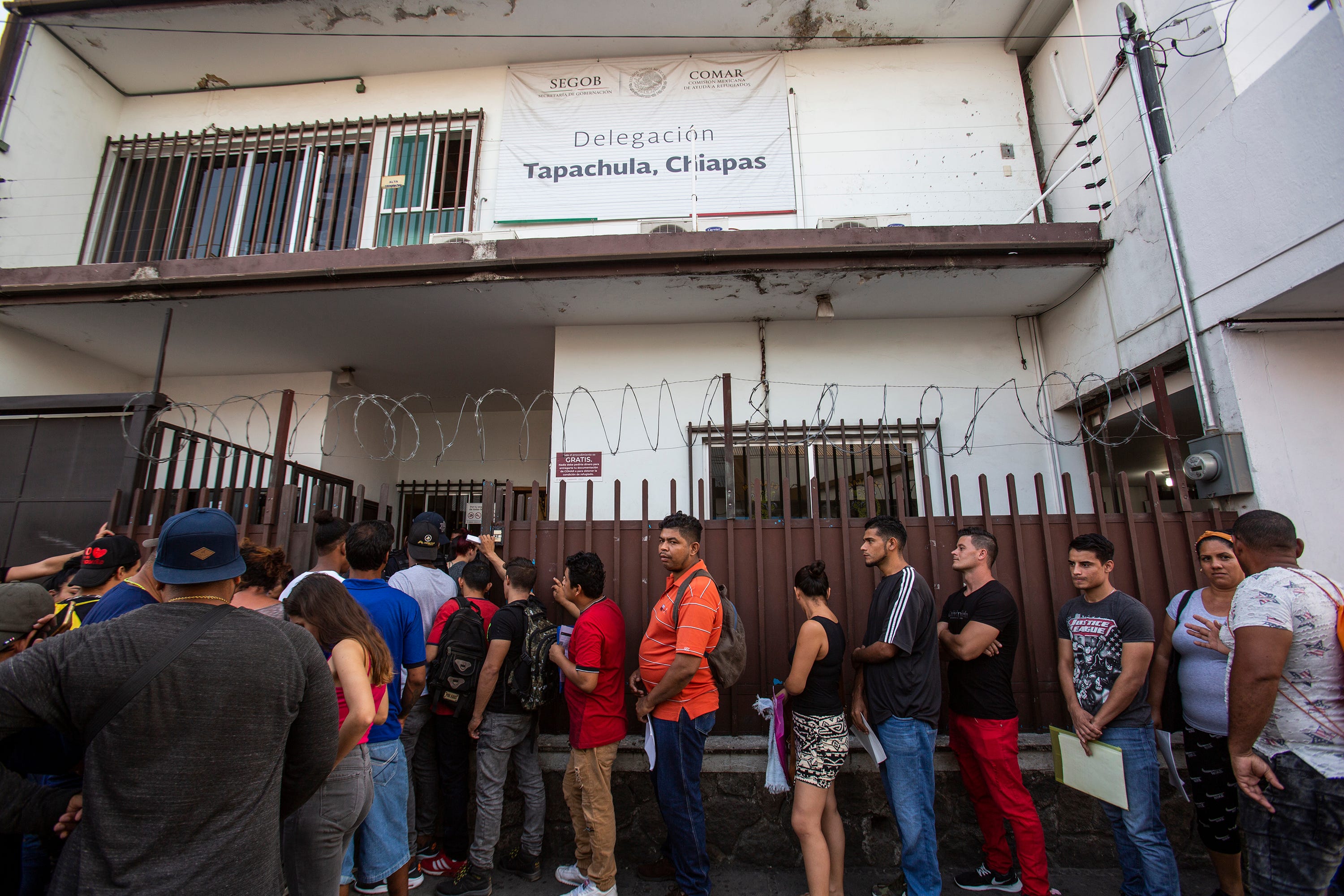 Migrants from diverse nations line up for interviews with the Mexico's commission for refugees, known as COMAR, in Tapachula, Mexico, in late February 2020. Many of the immigrants were seeking refuge in Mexico in order to safely continue their trek north towards the U.S.-Mexico border.