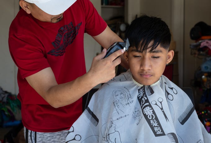 Eddie Barrios give his nephew, Geo Villamar an Easter haircut, April 12, 2020, in the garage of his Guadalupe home. Eddie was giving his nephew a haircut because all of the barber shops are closed due to the coronavirus.