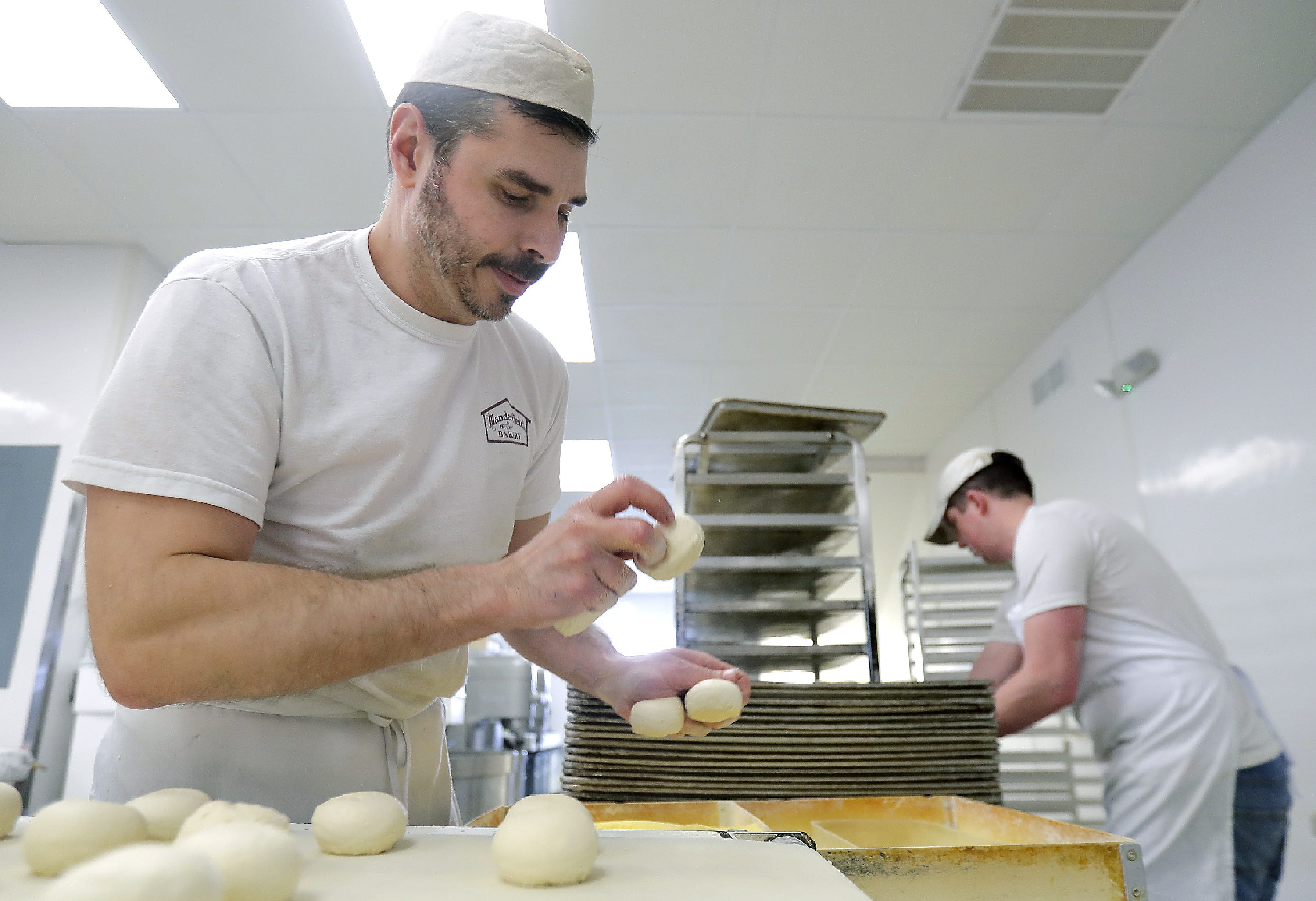 At Manderfield's Home Bakery on Appleton's east side, Bradley Jarvais, left, and JT Heenan roll dough for buns for wholesale accounts. The bakery will reopen this shop Wednesday, April 22, for retail customers.