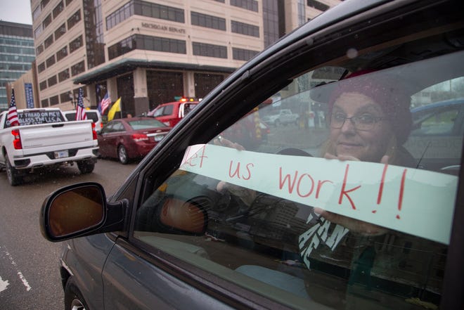 Kelly Dean a teacher from Lansing joins protesters as they block traffic around the Michigan State Capitol building in Lansing on April 15, 2020.
