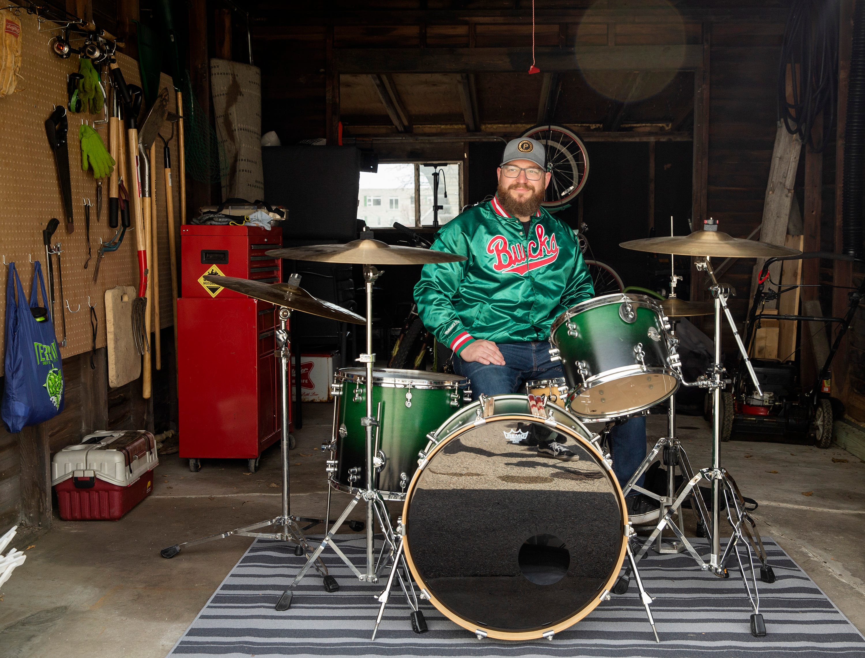 Kyle Ciske sits in front of his drum set in his garage in West Allis. Ciske was the head brewer for The Explorium Brewpub but was laid off nearly four weeks ago. Ciske has started filling the days with activities he once neglected.