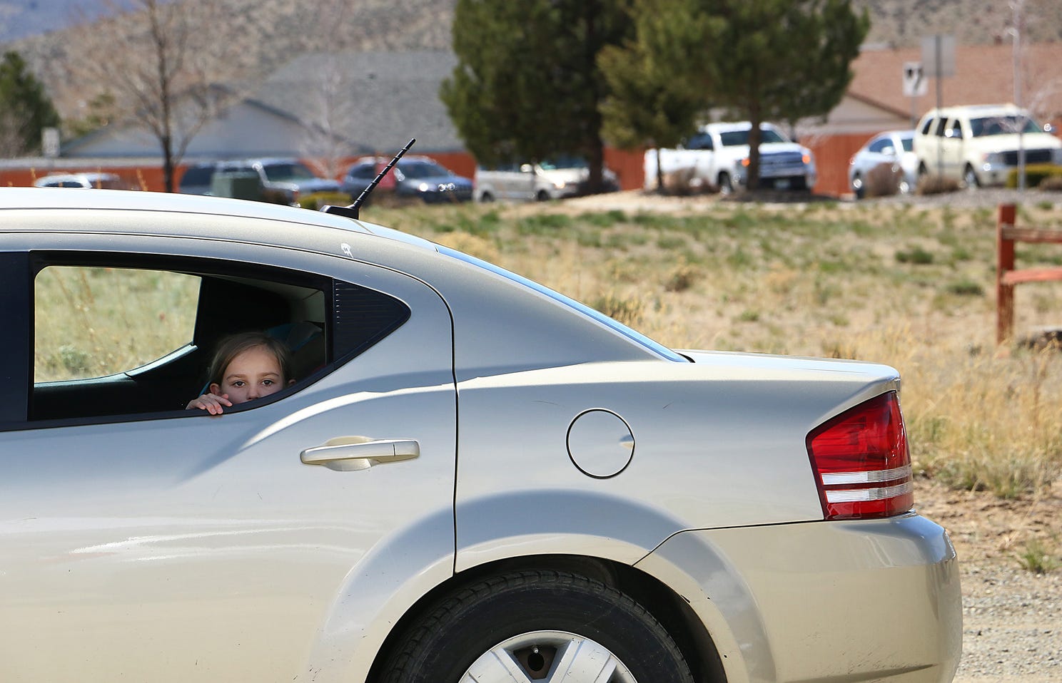 A child looks out the window of her family's car as hundreds of people line up to receive food from the Food Bank of Northern Nevada at the Cold Springs Family Center north of Reno on April 15, 2020.