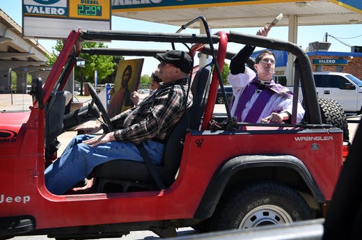 Father Peter Kavanaugh and his wife, Zoe, were driven around Wichita Falls Wednesday in a Jeep by Steve Forbes. Kavanaugh sprinkled holy water along the way, asking for God's protection on the people and saying prayers for health and healing. Father Kavanaugh is the minister at St. Benedict Orthodox Church.