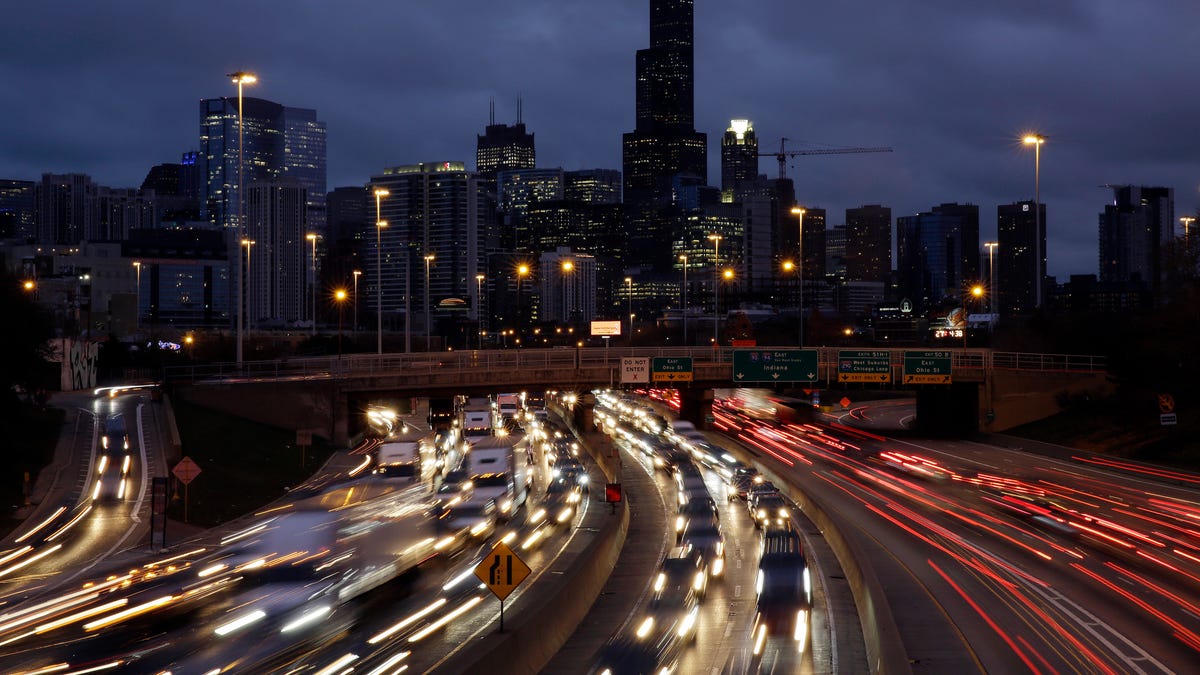 In this photo taken with a long exposure, traffic streaks across the John F. Kennedy Expressway at the start of the Thanksgiving holiday weekend, Wednesday, Nov. 21, 2018, in Chicago. Mild weather and falling gasoline prices are helping Thanksgiving travelers get where they're going while saving a few bucks.