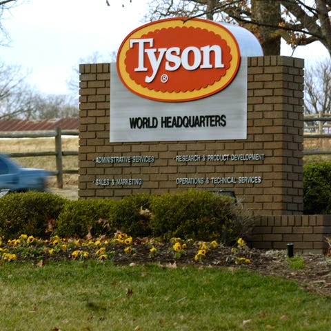 A car passes in front of a Tyson Foods Inc., sign 