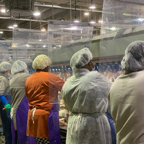 Workers are separated by sheeting at a Tyson Foods