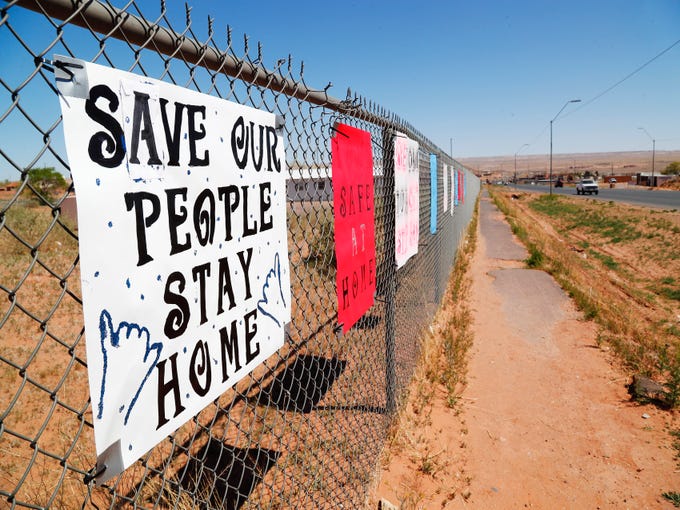 Signs on a fence in Tuba City, Ariz. reminds residents shelter in place to fight against the coronavirus April 14, 2020. The Navajo Reservation has seen a spike in COVID-19 cases.