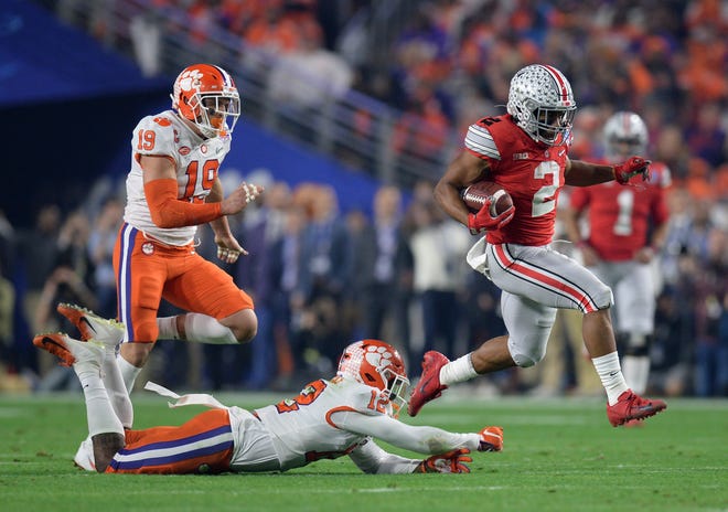 Ohio State Buckeyes running back J.K. Dobbins (2) gets past Clemson Tigers safety K'Von Wallace (12) during the first quarter in the 2019 Fiesta Bowl college football playoff semifinal game.