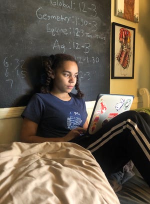 Ella Canady, 15, completes her school work online at home in Phoenix, Ariz. Like many other teens, she's dealing with the stress of missing school and friends under stay-at-home orders to contain the coronavirus.