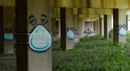 A cyclist passes coronavirus-related graffiti under an overpass in San Antonio, Thursday, April 16, 2020. San Antonio remains under stay-at-home orders due to the COVID-19 outbreak.