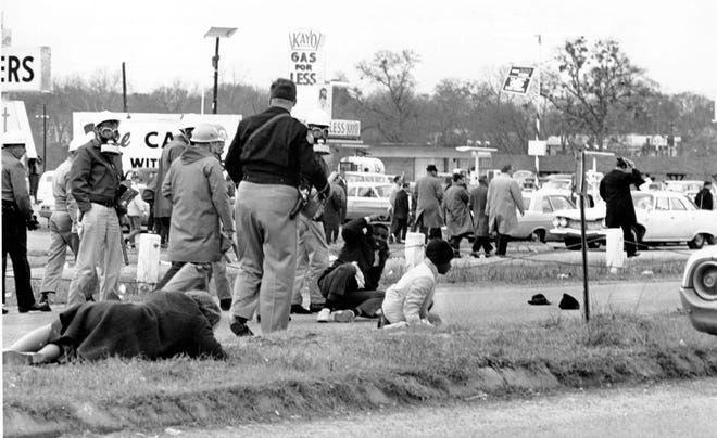 Civil rights demonstrators struggle on the ground as state troopers use violence to break up a march in Selma, Ala., on what is known as Bloody Sunday on March 7, 1965.  The supporters of black voting rights organized a march from Selma to Montgomery to protest the killing of a demonstrator by a state trooper and to improve voter registration for blacks, who are discouraged to register.  (AP Photo)