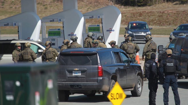 Royal Canadian Mounted Police prepare to take a person into custody at a gas station in Enfield, Nova Scotia, on April 19 after several people were harmed.