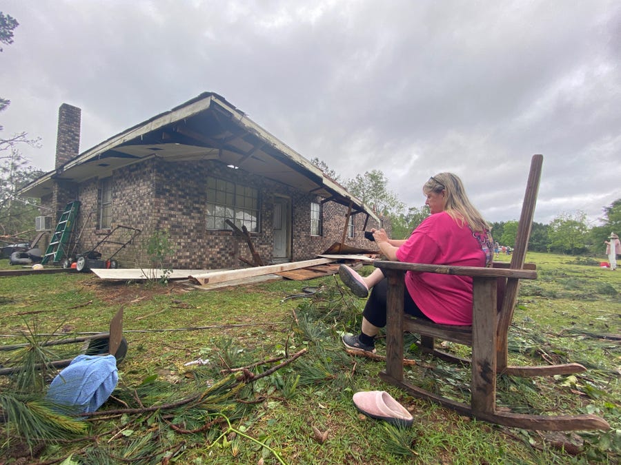 Penny Temples, a teacher at Lumberton High School, assesses damage April 20, the morning after a tornado struck Baxterville, Miss.