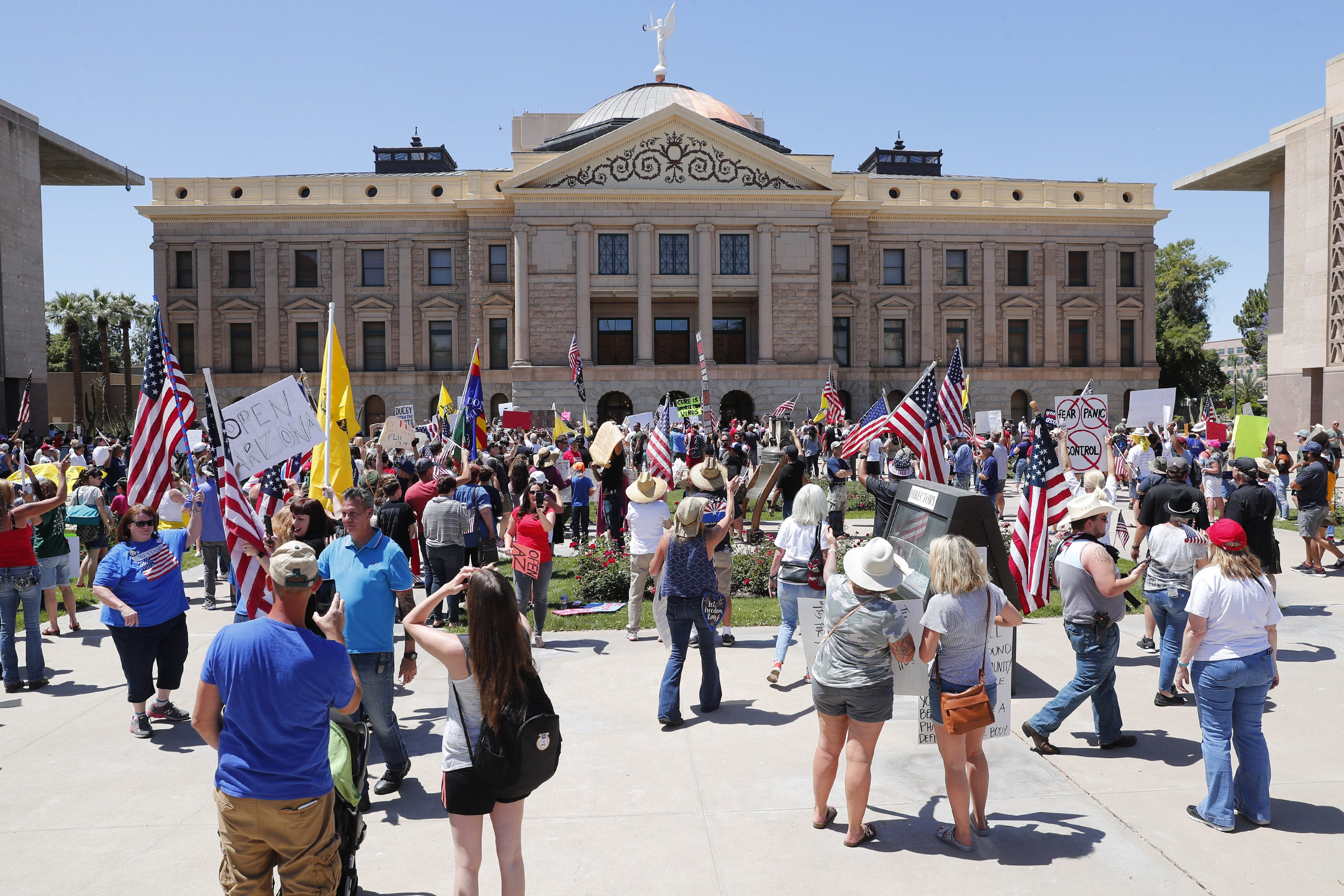 People gather outside the Arizona state Capitol in protest of Gov. Doug Ducey's stay-at-home order to combat the coronavirus April 20, 2020.