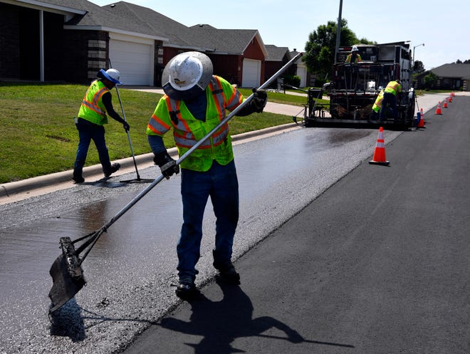 Road crews seal coat part of Cotton Candy Road Tuesday.