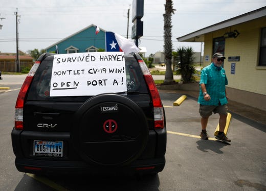 A "Survived Harvey Don't let CV-19 Win! Open Port A!" sign is seen before the driving protest, Tuesday, April 21, 2020, in Port Aransas. The protest opposes the mayoral declaration that prohibits certain kinds of business activity to prevent the spread of the coronavirus.