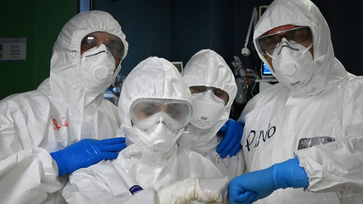 Health workers, wearing protective gear pose at the end of their shift at the level intensive care unit, treating COVID-19 patients, at the San Filippo Neri hospital in Rome, on April 20, 2020, during the country's lockdown aimed at stopping the spread of the COVID-19 (new coronavirus) pandemic.