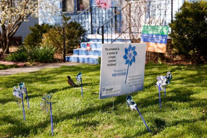 Pinwheels sit in the yard of a home to raise awareness for child abuse, Wednesday, April 22, 2020 in West Lafayette. "This pinwheel is a symbol of a happy childhood. This pinwheel garden represents what we all want for every child in Tippecanoe County," reads the sign.
