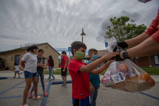 Children in Mecca receive food from the Coachella Valley Unified School District. Many farmworkers have seen their income reduced under COVID-19 and are now more dependent on food for their children from the school district.  March 6, 2020.