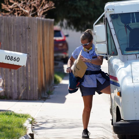 U.S. Postal Service carrier Amy Bezerra loads mail