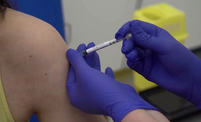 Screen grab taken from video issued by Britain's Oxford University, showing microbiologist Elisa Granato, being injected as part of the first human trials in the UK for a potential coronavirus vaccine.