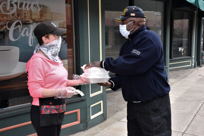 Kelly Vassallo of Barista Blue Cafe does curbside service for Danny Moss outside the restaurant at 91 West Michigan Ave. on Friday, April 24, 2020.