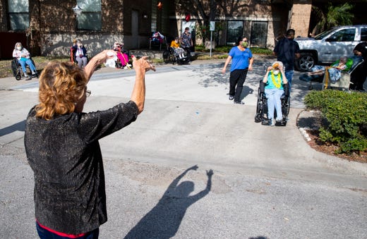 People wave to their family members at the Alameda Oaks nursing center as they take part in a parade on Friday, Aril 24, 2020. Alameda Oaks nursing center hosted a parade for its residents, who have not had visitors since the start of the COVID-19 outbreak.