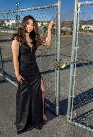 Senior Tali Bertinuson stands outside the locked gates of Fernley High School in her prom dress.
