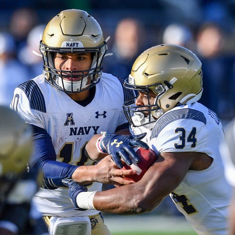Navy quarterback Malcolm Perry (10) hands off to f