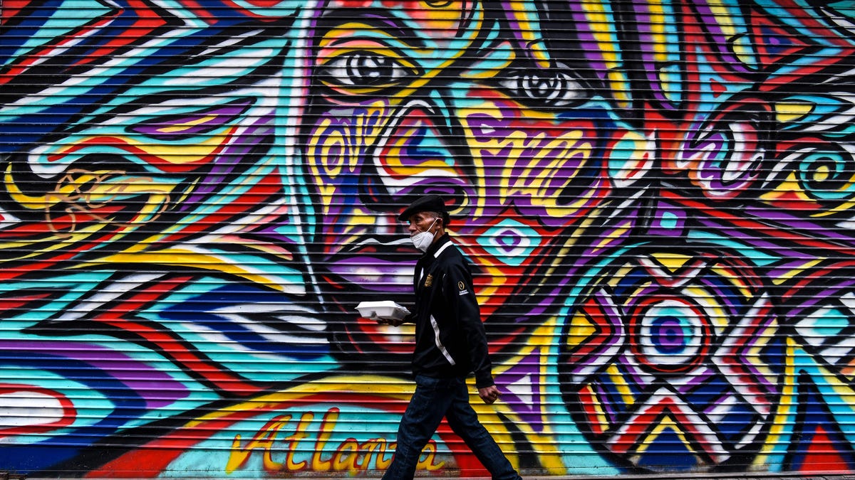 A man wears a mask amid fears over the spread of the novel coronavirus (which causes COVID-19) as he walks past a mural in downtown in Atlanta, Georgia, on April 23, 2020. The US state of Georgia takes a massive gamble on April 24 when it allows businesses like gyms and hair salons to re-open to ease a painful coronavirus lockdown, a move even President Donald Trump fears is too soon.