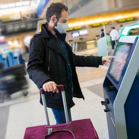 An airport traveler wears a face mask.