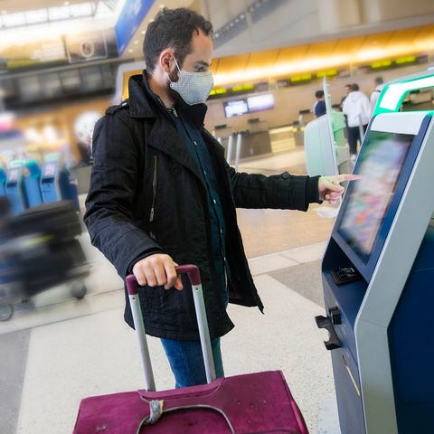 An airport traveler wears a face mask.