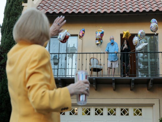Friends from the neighborhood walk by the home of James Keller who was celebrating his 93rd birthday Friday.