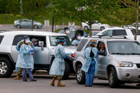 Montgomery County healthcare workers and Tennessee Air and Army National Guard Medical Task Force members speak with patients arriving at the COVID-19 coronavirus drive-thru testing site at the Montgomery County Health Department in Clarksville, Tenn., on Sunday, April 26, 2020. 