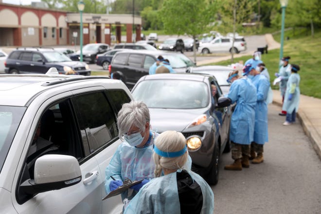 Montgomery County healthcare workers speak with patients while filling out paperwork before administering a swab test at the COVID-19 coronavirus drive-thru testing site at the Montgomery County Health Department in Clarksville, Tenn., on Sunday, April 26, 2020. 