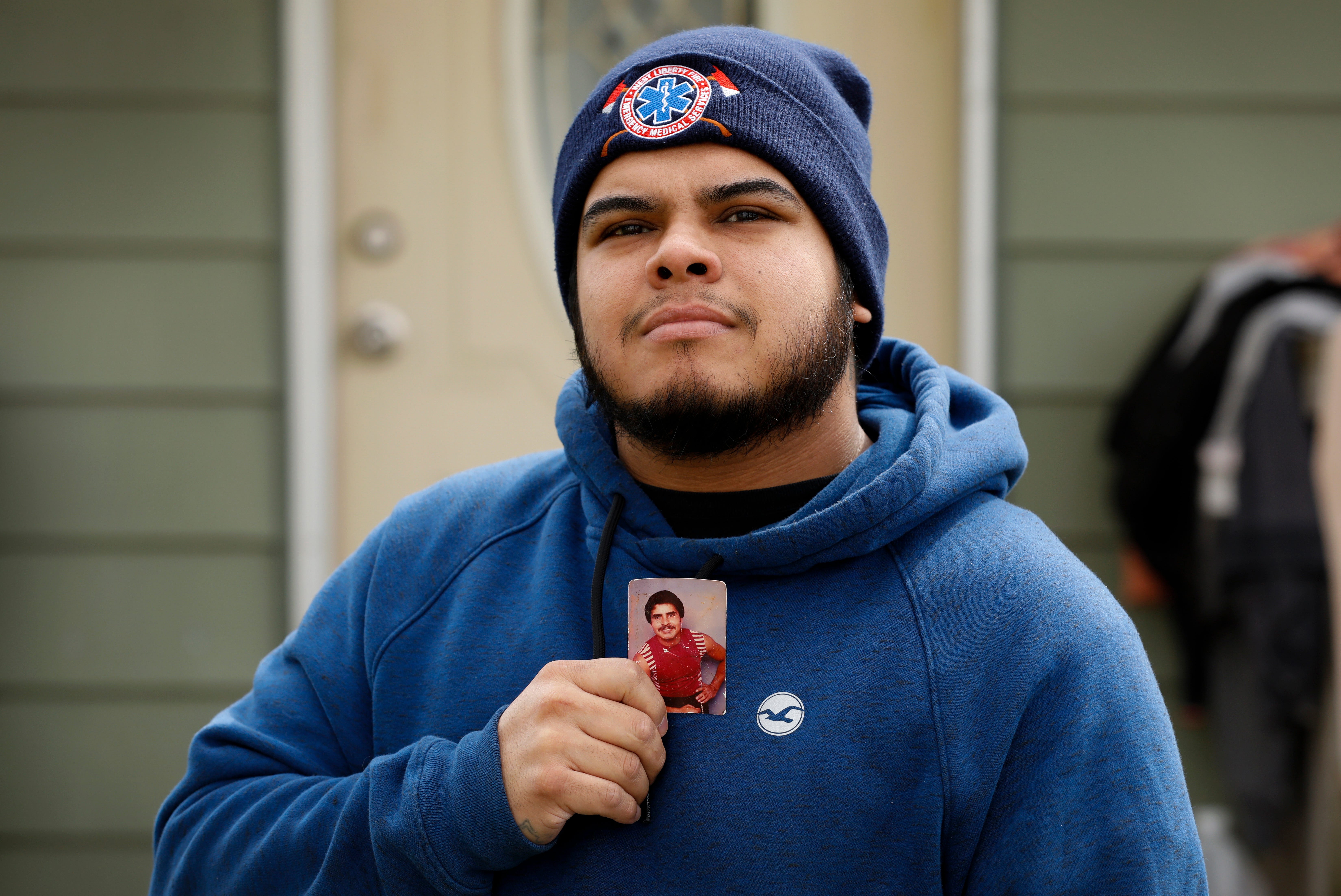 Omar Martinez poses for a photo with a portrait of his father Jose Gabriel Martinez, who died of COVID-19.